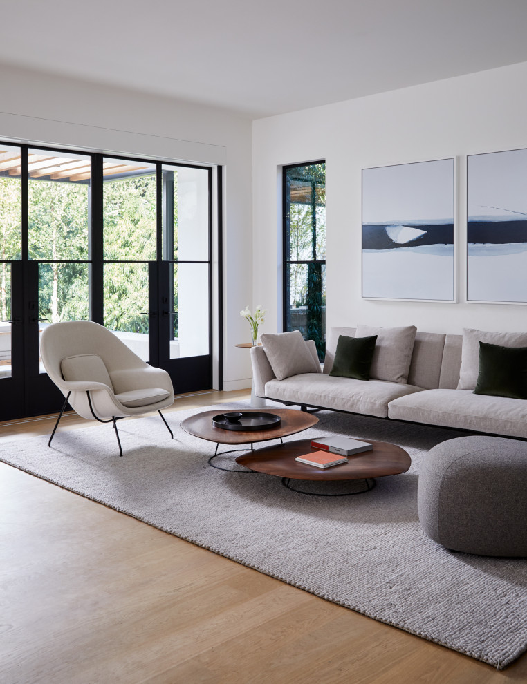 Идея дизайна: открытая гостиная комната в стиле модернизм с белыми стенами, светлым паркетным полом и бежевым полом
