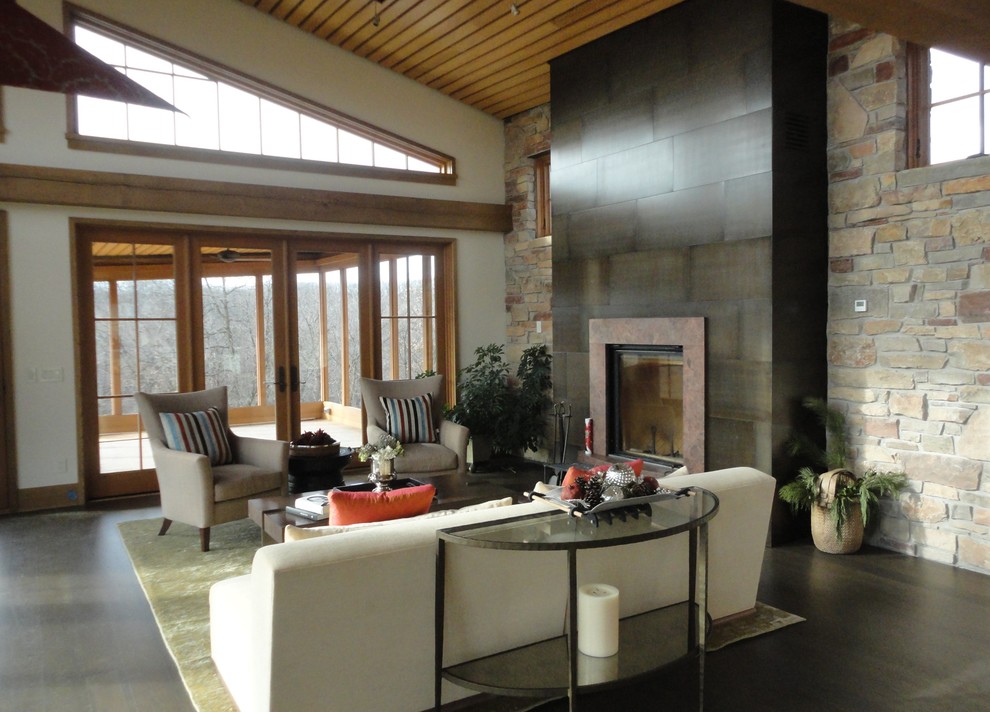 Aménagement d'un grand salon moderne avec un mur beige, parquet foncé, une cheminée standard et un manteau de cheminée en pierre.