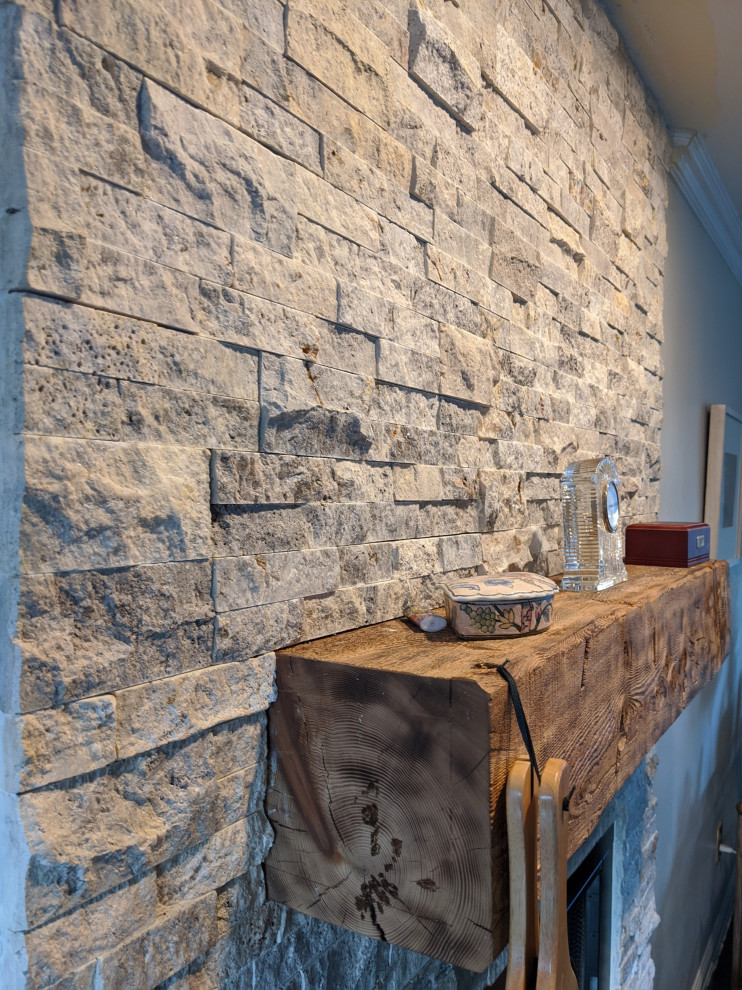 На фото: открытая гостиная комната среднего размера в стиле ретро с стандартным камином, фасадом камина из каменной кладки и коричневым полом