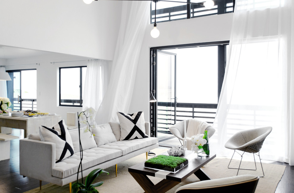 На фото: открытая гостиная комната в морском стиле с белыми стенами и темным паркетным полом