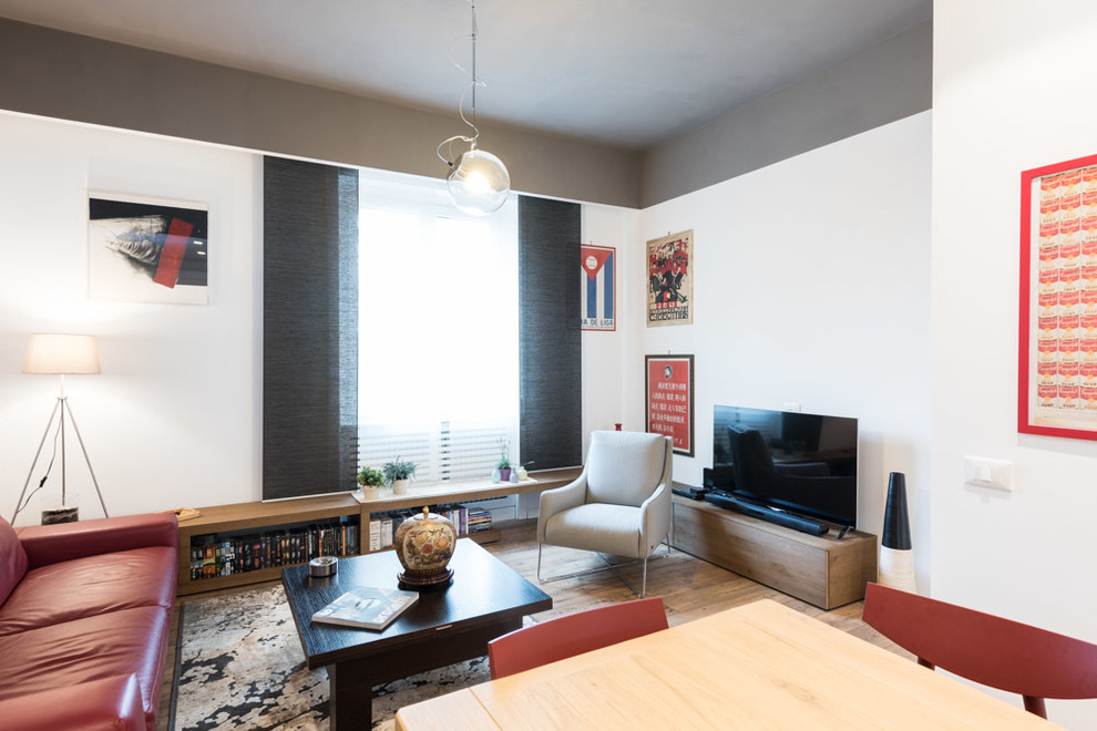 Offenes Modernes Wohnzimmer ohne Kamin mit hellem Holzboden und freistehendem TV in Rom