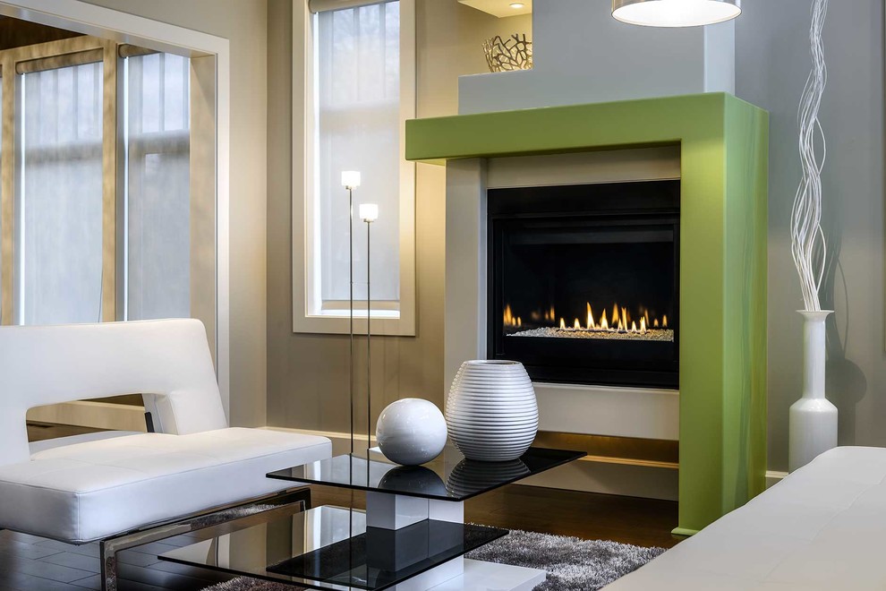 Exemple d'un salon tendance avec un mur vert, une cheminée standard et un manteau de cheminée en plâtre.