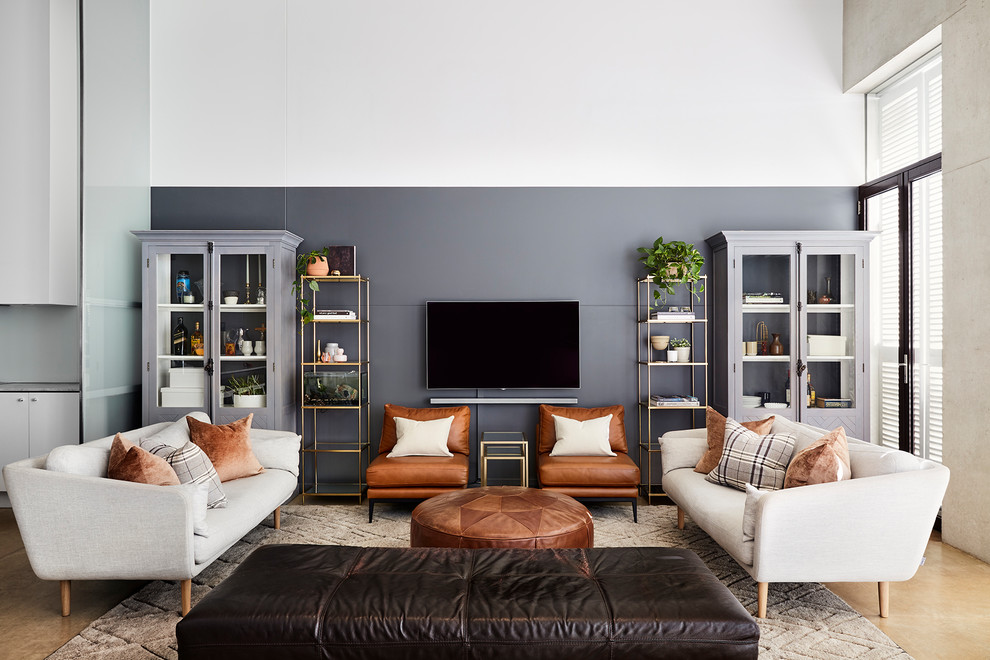 Стильный дизайн: открытая гостиная комната в современном стиле с серыми стенами, телевизором на стене и бежевым полом без камина - последний тренд