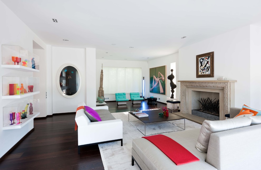 Großes, Fernseherloses, Abgetrenntes Modernes Wohnzimmer mit weißer Wandfarbe, dunklem Holzboden, Kamin, Kaminumrandung aus Stein und braunem Boden in London