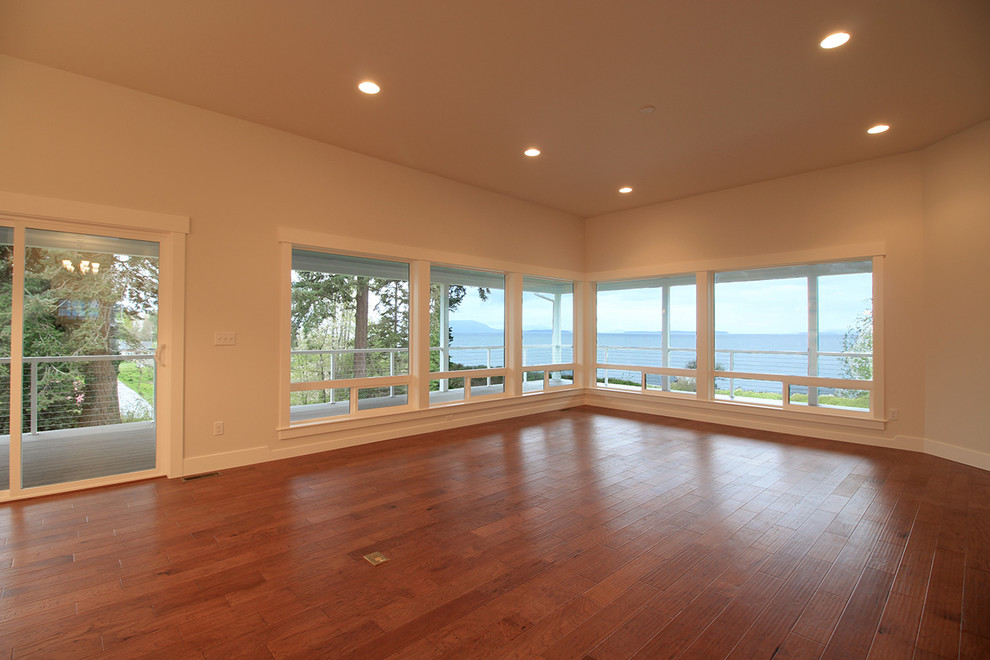 На фото: большая открытая гостиная комната в морском стиле с белыми стенами и паркетным полом среднего тона без камина, телевизора