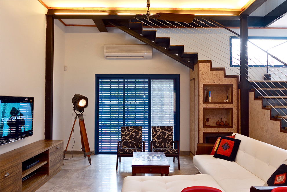 На фото: гостиная комната в стиле фьюжн с бежевыми стенами, бетонным полом и телевизором на стене с