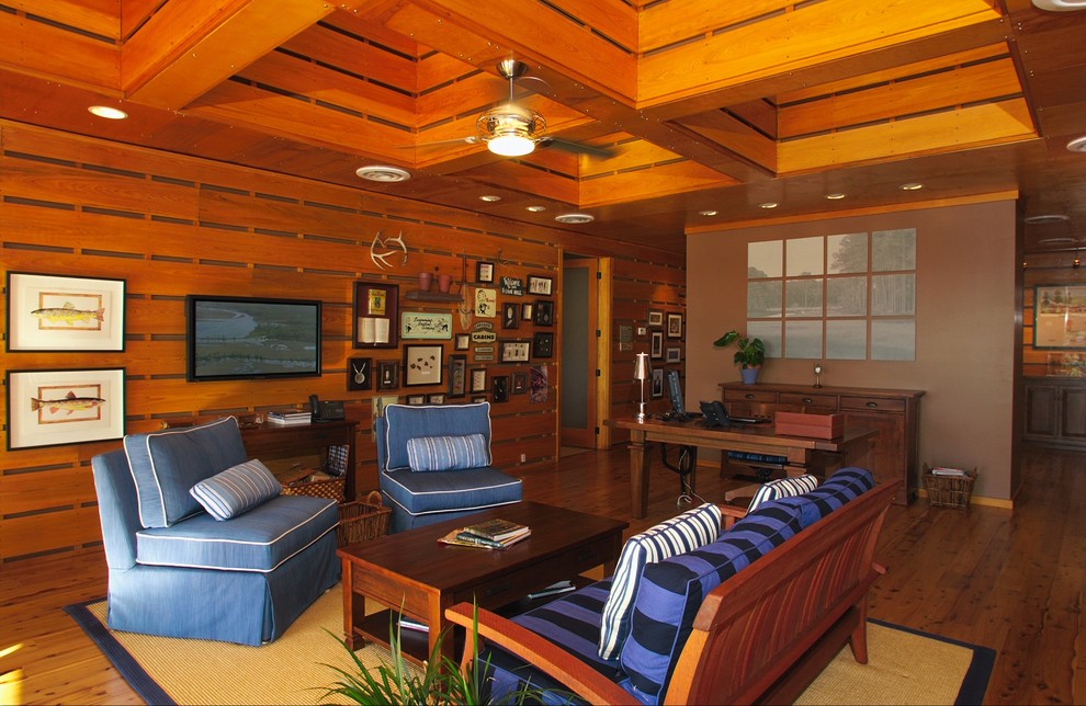 Immagine di un soggiorno tropicale con TV a parete e tappeto