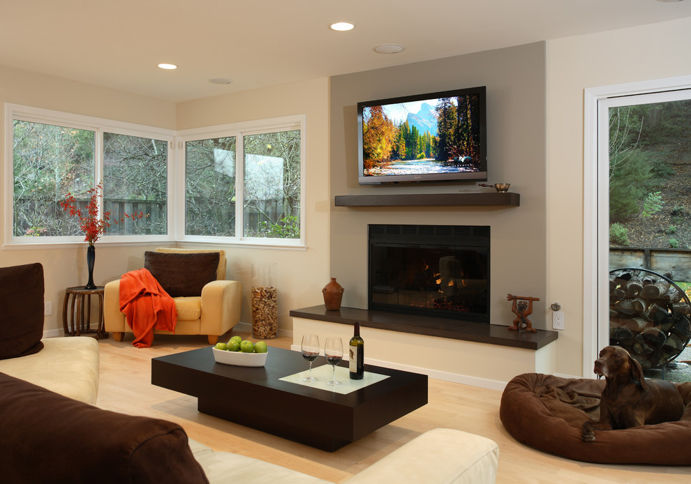 Example of a mid-sized trendy formal and open concept light wood floor living room design in San Francisco with beige walls, a standard fireplace, a concrete fireplace and a wall-mounted tv