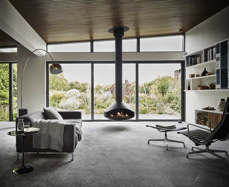 Inspiration pour un grand salon design ouvert avec un mur gris, moquette, cheminée suspendue, un téléviseur encastré et un sol gris.