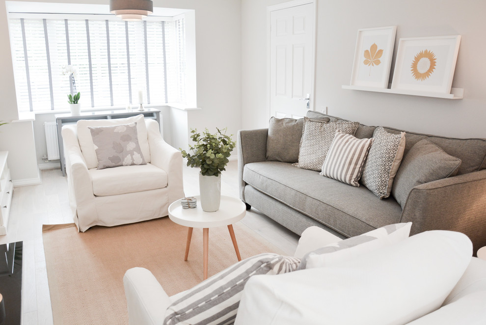 Cette photo montre un salon scandinave avec un mur blanc, parquet clair, un téléviseur indépendant et un sol beige.