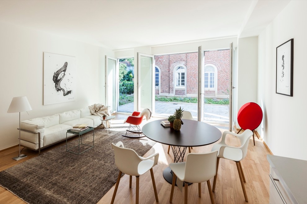 Mittelgroßes Skandinavisches Wohnzimmer mit weißer Wandfarbe, braunem Holzboden und braunem Boden in Sonstige