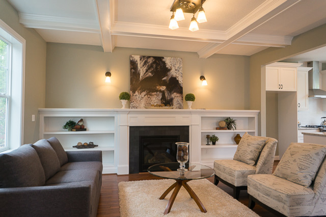 Mittelgroßes, Offenes Uriges Wohnzimmer mit beiger Wandfarbe, braunem Holzboden, Kamin, gefliester Kaminumrandung und TV-Wand in Portland
