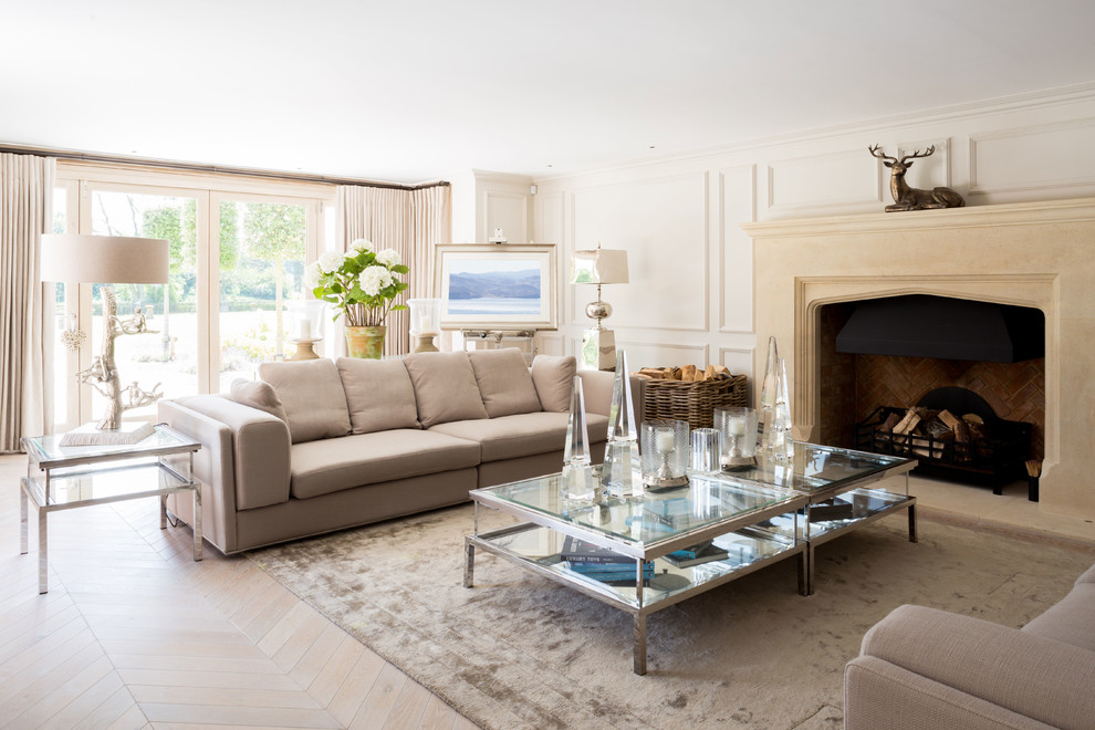Inspiration for a large country formal living room in West Midlands with white walls, light hardwood flooring, a standard fireplace, a stone fireplace surround, no tv and beige floors.