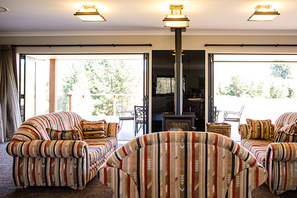 Esempio di un grande soggiorno country aperto con moquette, camino classico e pavimento marrone