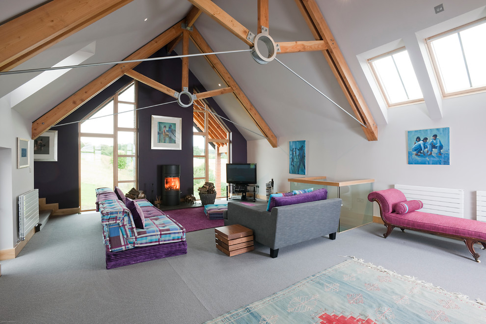 Esempio di un soggiorno contemporaneo stile loft con moquette e stufa a legna