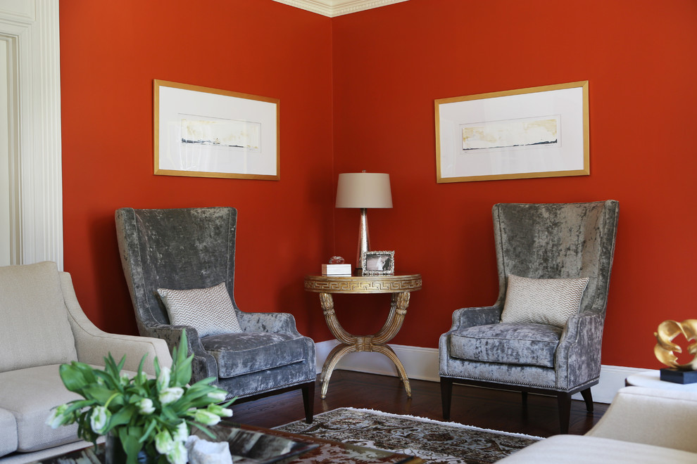 Cette image montre un salon traditionnel de taille moyenne et fermé avec une salle de réception, un mur rouge, moquette, une cheminée standard, un manteau de cheminée en pierre, aucun téléviseur et un sol multicolore.