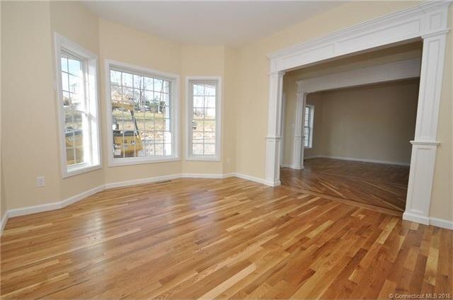 Klassisches Wohnzimmer mit beiger Wandfarbe und braunem Holzboden in Bridgeport