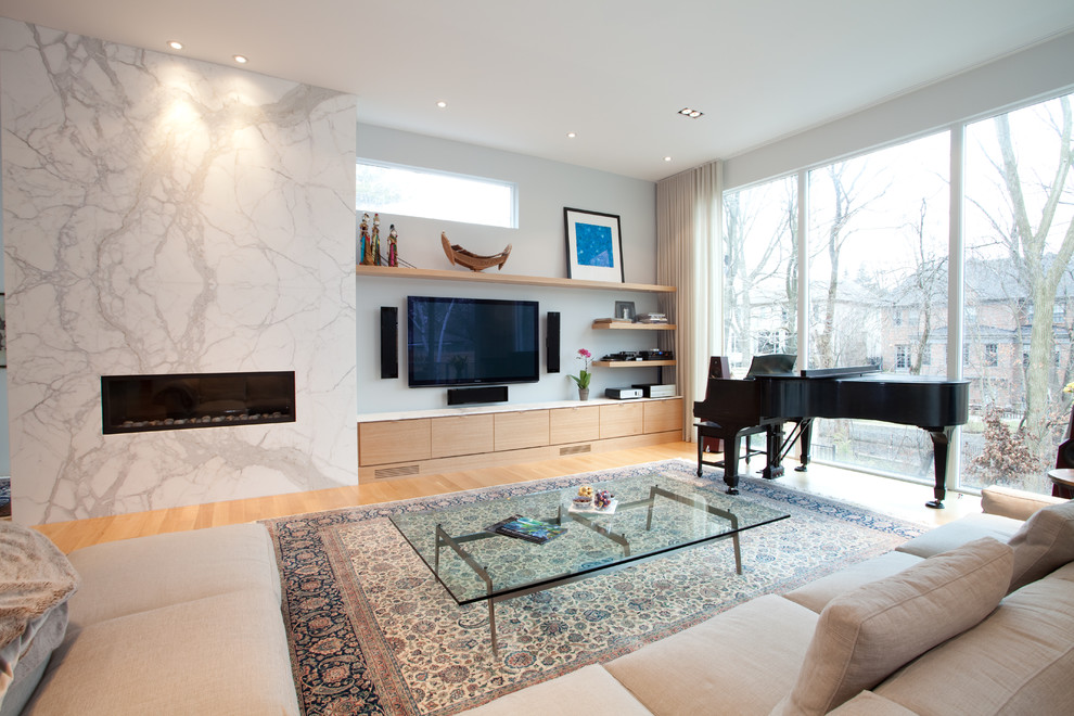 This is an example of a medium sized contemporary open plan living room in Toronto with a music area, medium hardwood flooring, a ribbon fireplace and a wall mounted tv.