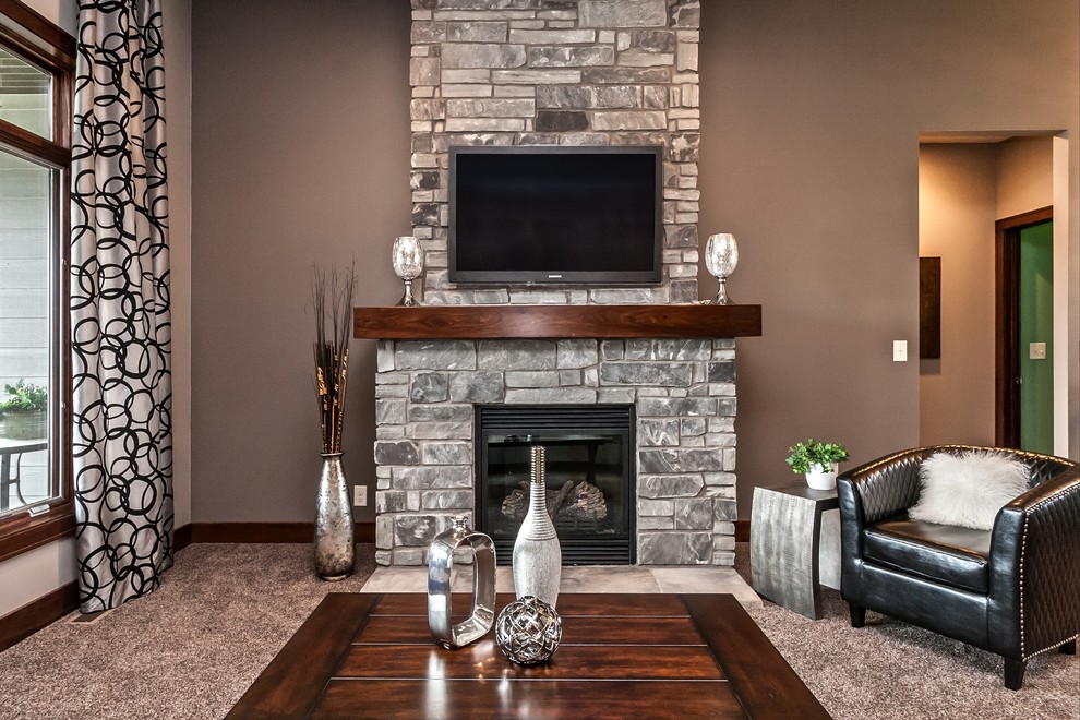Ejemplo de salón moderno con todas las chimeneas, marco de chimenea de piedra y televisor colgado en la pared