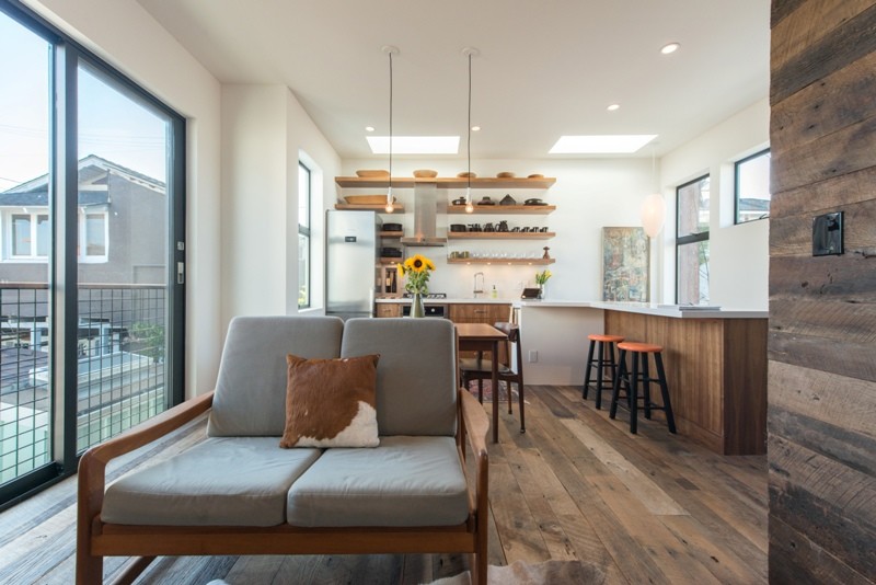 Foto di un soggiorno minimalista di medie dimensioni e stile loft con pavimento in legno massello medio, pareti bianche, nessun camino e TV a parete