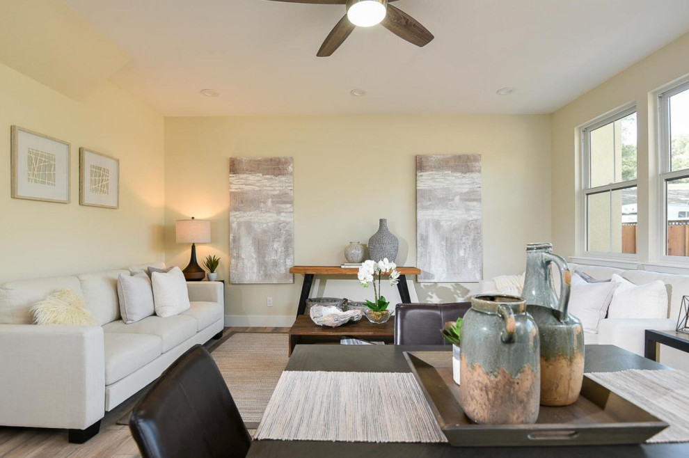 Foto di un soggiorno contemporaneo di medie dimensioni e aperto con pareti beige, pavimento in laminato e pavimento grigio