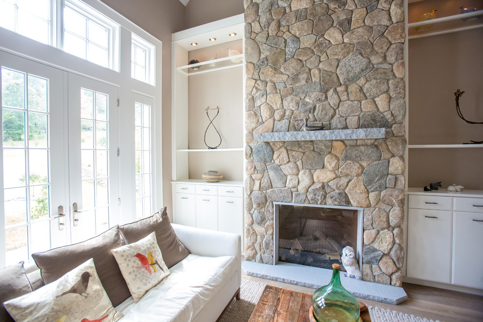 Ispirazione per un soggiorno tradizionale di medie dimensioni con pareti beige, moquette, camino classico e cornice del camino in pietra