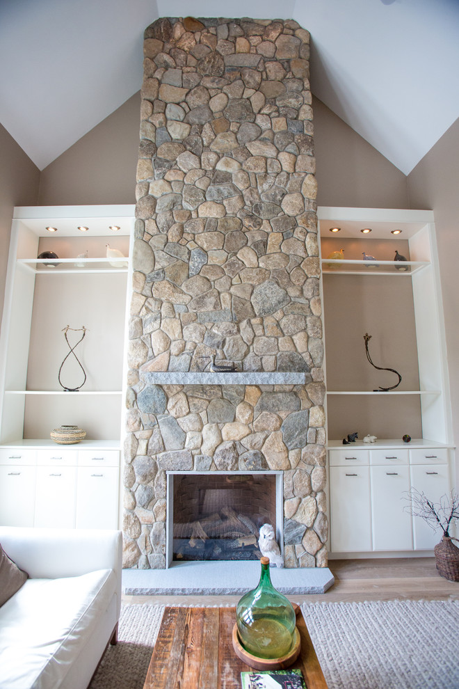 Modelo de salón tradicional de tamaño medio con paredes beige, moqueta, todas las chimeneas y marco de chimenea de piedra