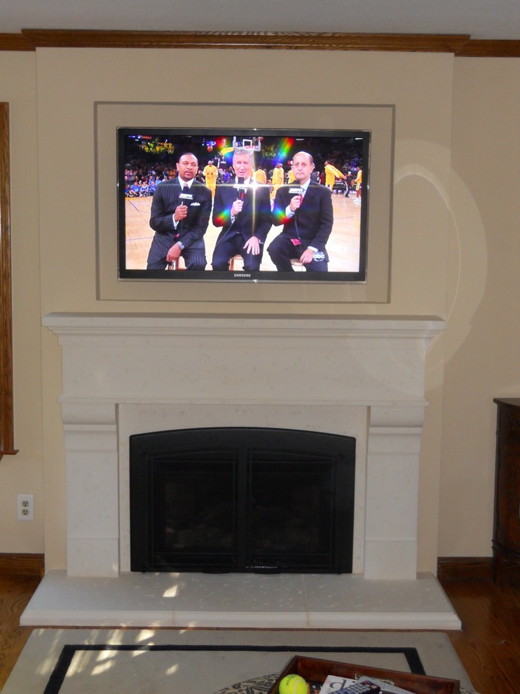 Example of a mid-sized classic medium tone wood floor and brown floor living room design in San Francisco with beige walls, a standard fireplace, a stone fireplace and a wall-mounted tv