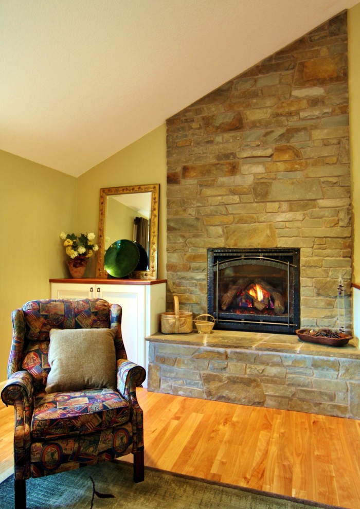 ポートランドにあるラグジュアリーな広いトラディショナルスタイルのおしゃれなLDK (ベージュの壁、無垢フローリング、標準型暖炉、石材の暖炉まわり、壁掛け型テレビ) の写真