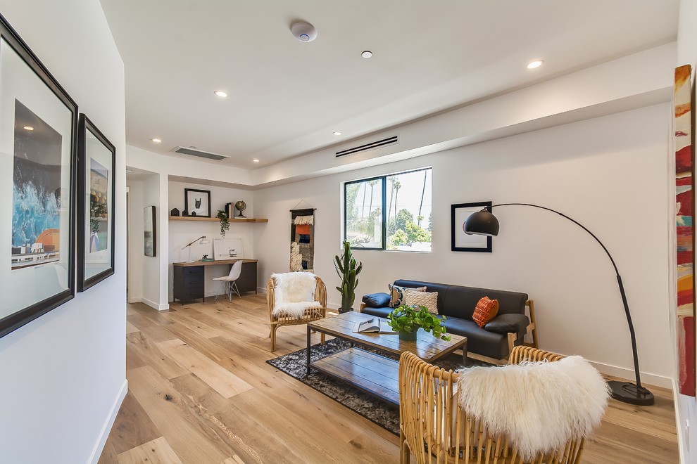 Immagine di un soggiorno stile marinaro aperto con pareti bianche, pavimento marrone, sala formale e parquet chiaro