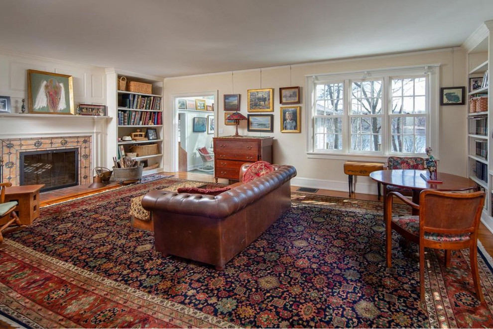 Geräumiges, Offenes Klassisches Wohnzimmer mit beiger Wandfarbe, braunem Holzboden, Kamin und gefliester Kaminumrandung in Philadelphia