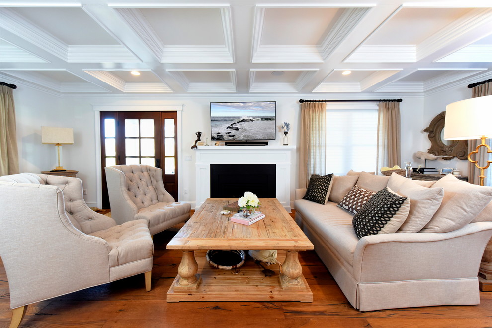 Esempio di un soggiorno stile marinaro con sala formale, pareti bianche, pavimento in legno massello medio, camino classico e TV a parete