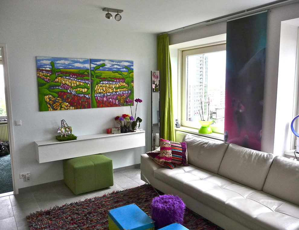 Источник вдохновения для домашнего уюта: большая открытая гостиная комната в стиле фьюжн с белыми стенами, полом из керамической плитки и телевизором на стене