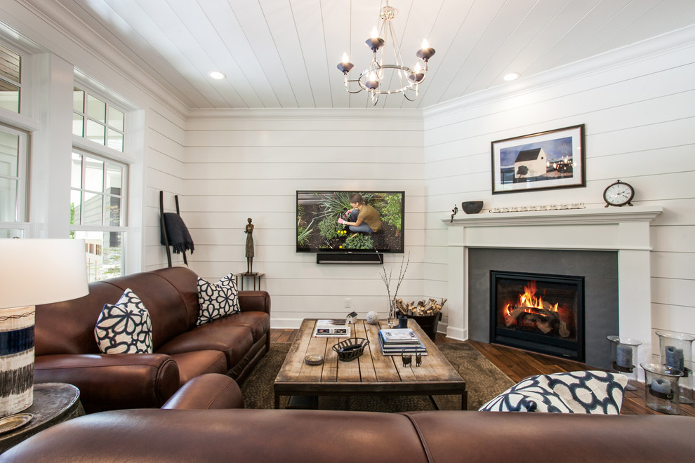 Repräsentatives Landhaus Wohnzimmer mit weißer Wandfarbe, dunklem Holzboden, Kamin, TV-Wand und braunem Boden in New York