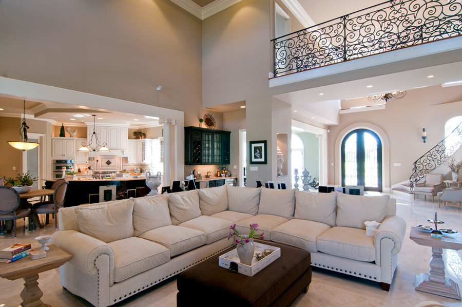 Immagine di un grande soggiorno mediterraneo aperto con pareti beige, pavimento in pietra calcarea e pavimento beige