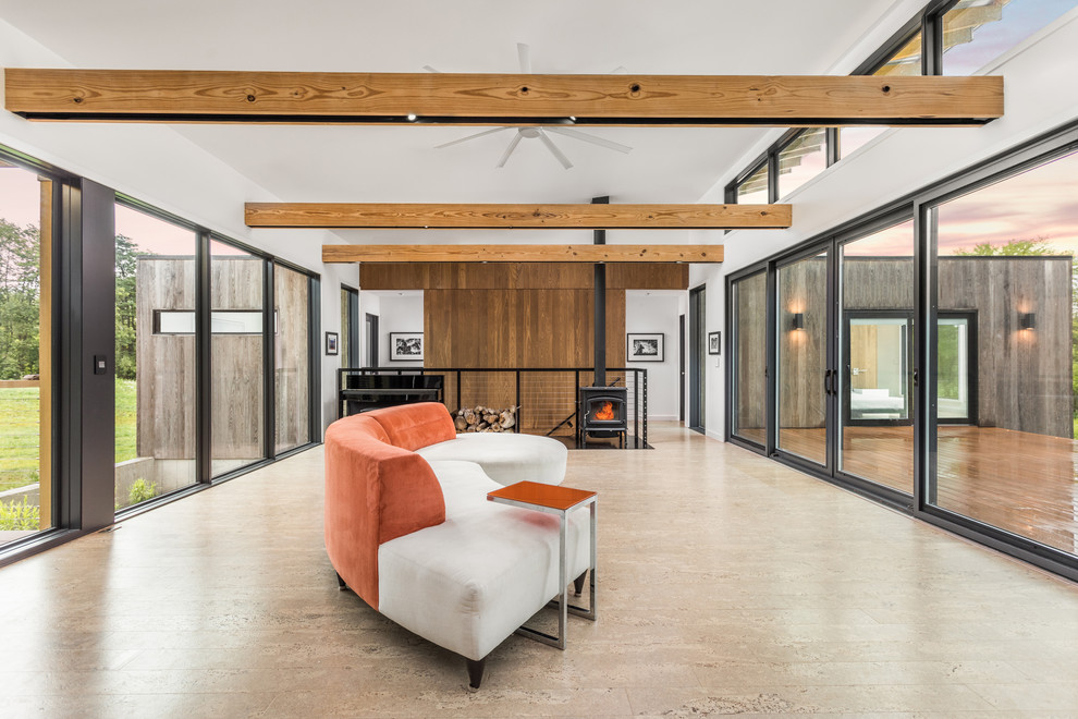 Стильный дизайн: открытая гостиная комната среднего размера в стиле модернизм с белыми стенами, пробковым полом, печью-буржуйкой, фасадом камина из металла и бежевым полом - последний тренд