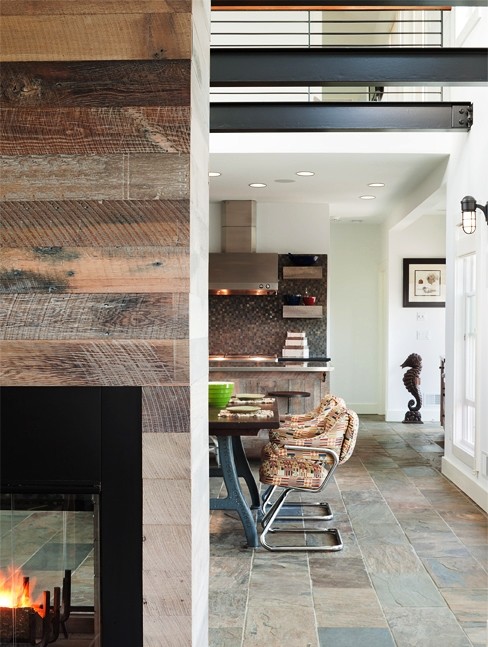 ニューヨークにある高級な小さなビーチスタイルのおしゃれなLDK (スレートの床、壁掛け型テレビ、白い壁、両方向型暖炉、木材の暖炉まわり、マルチカラーの床) の写真