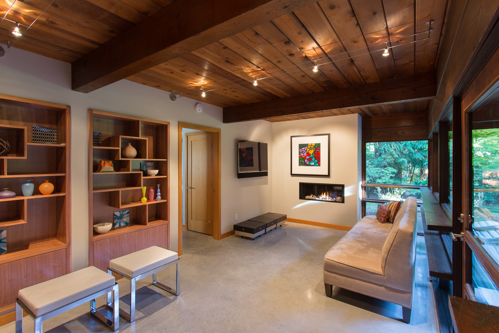 Offenes Retro Wohnzimmer mit Gaskamin, weißer Wandfarbe, verputzter Kaminumrandung, TV-Wand, grauem Boden und Betonboden in Vancouver