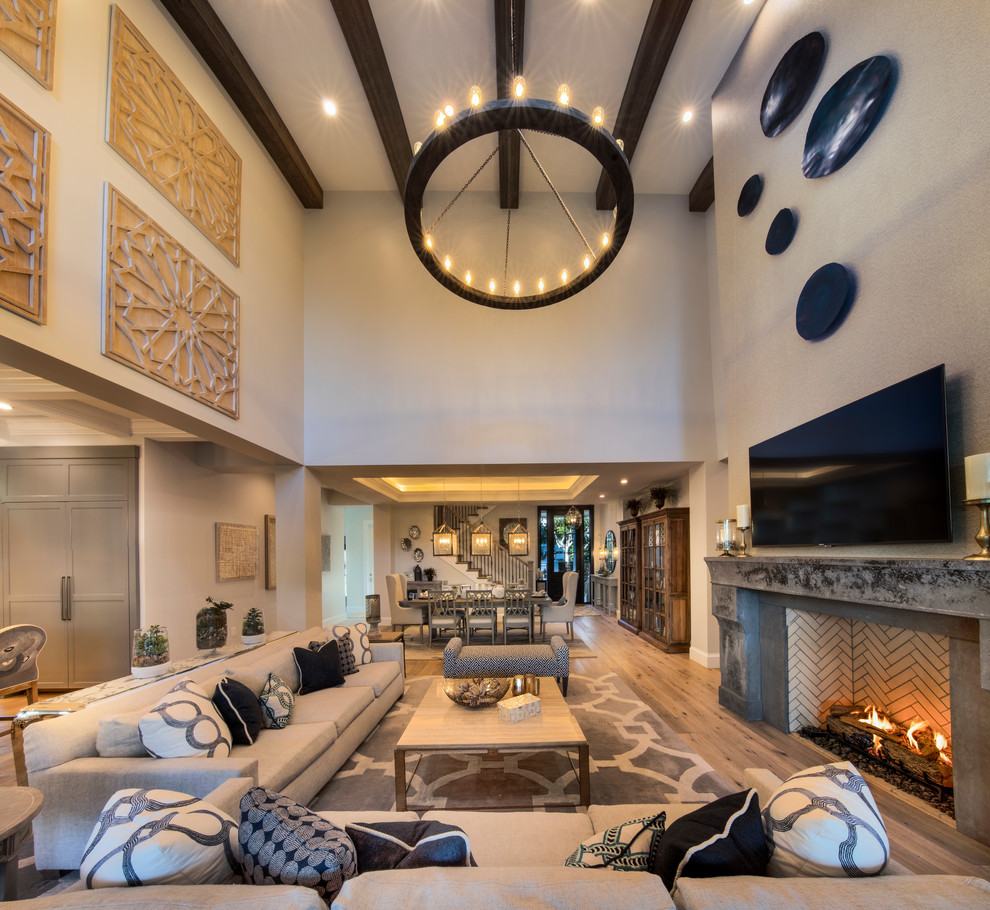 Immagine di un ampio soggiorno chic aperto con sala formale, pareti beige, pavimento in legno massello medio, camino classico, TV a parete e pavimento marrone