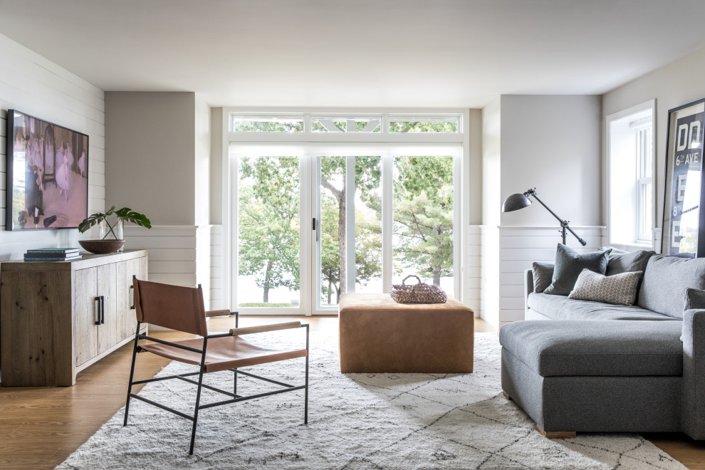 Immagine di un soggiorno chic con pareti grigie, pavimento in legno massello medio, pavimento marrone e boiserie