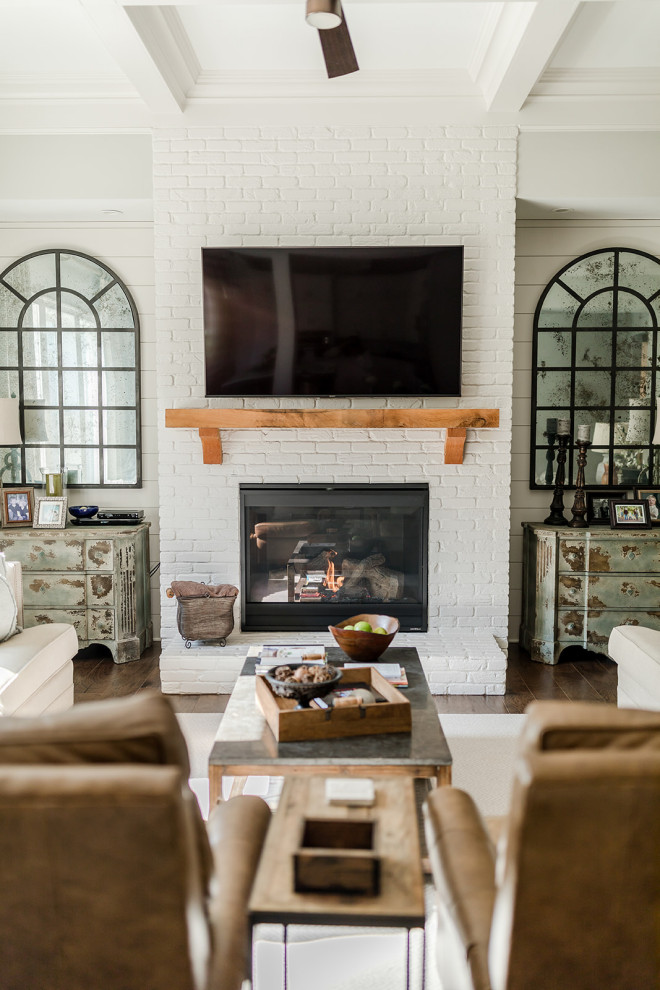 Cottage dark wood floor and brown floor living room photo in Atlanta with gray walls, a standard fireplace, a brick fireplace and a wall-mounted tv