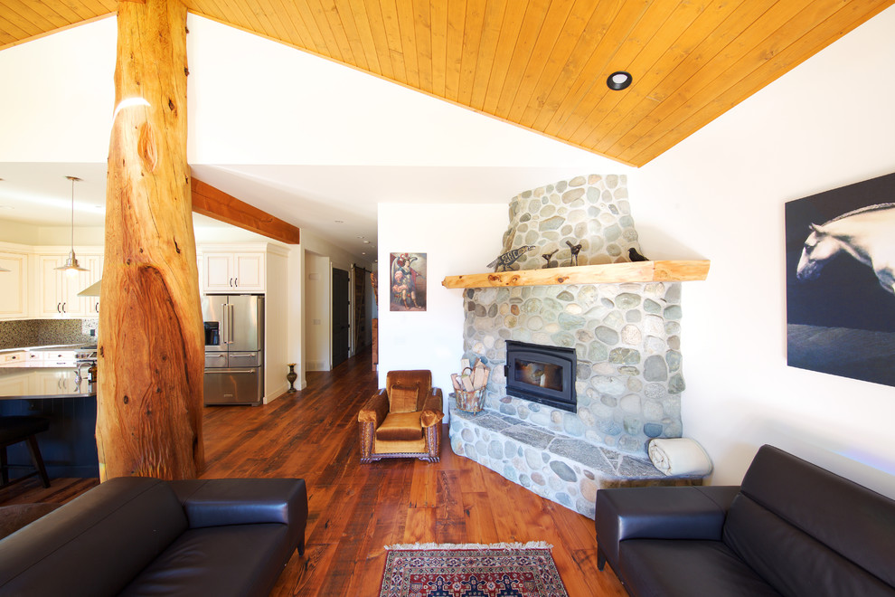 Kleines, Repräsentatives, Offenes Rustikales Wohnzimmer mit weißer Wandfarbe, braunem Holzboden, Eckkamin und Kaminumrandung aus Stein in Vancouver