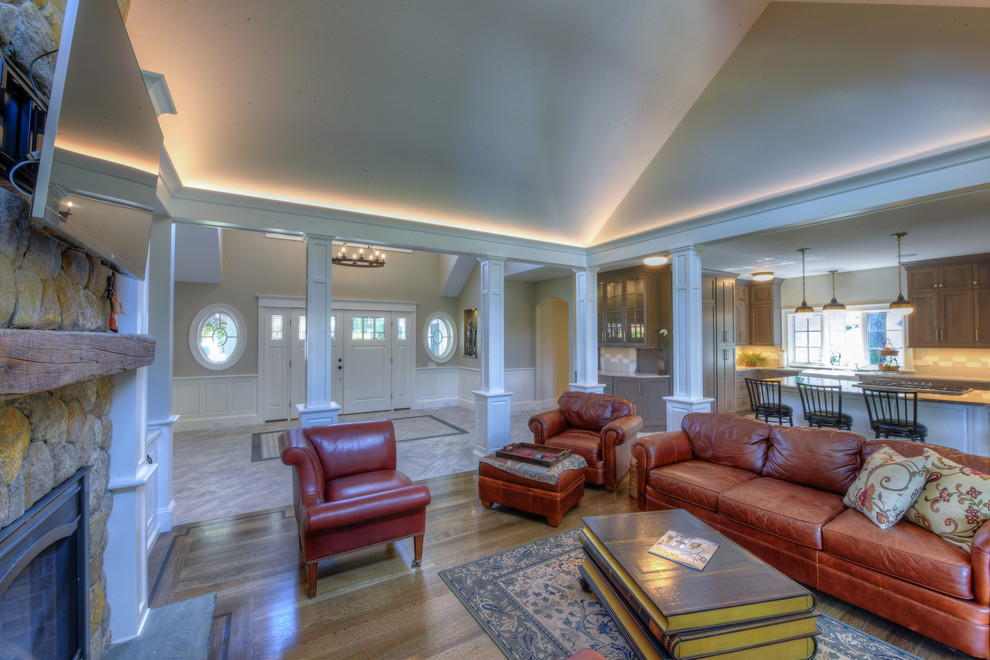 Großes, Abgetrenntes Klassisches Wohnzimmer mit beiger Wandfarbe, braunem Holzboden, Kamin, Kaminumrandung aus Stein und TV-Wand in Boston