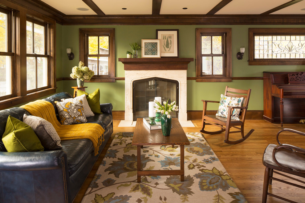 Esempio di un soggiorno stile americano con sala formale, pareti verdi, pavimento in legno massello medio, camino classico e nessuna TV