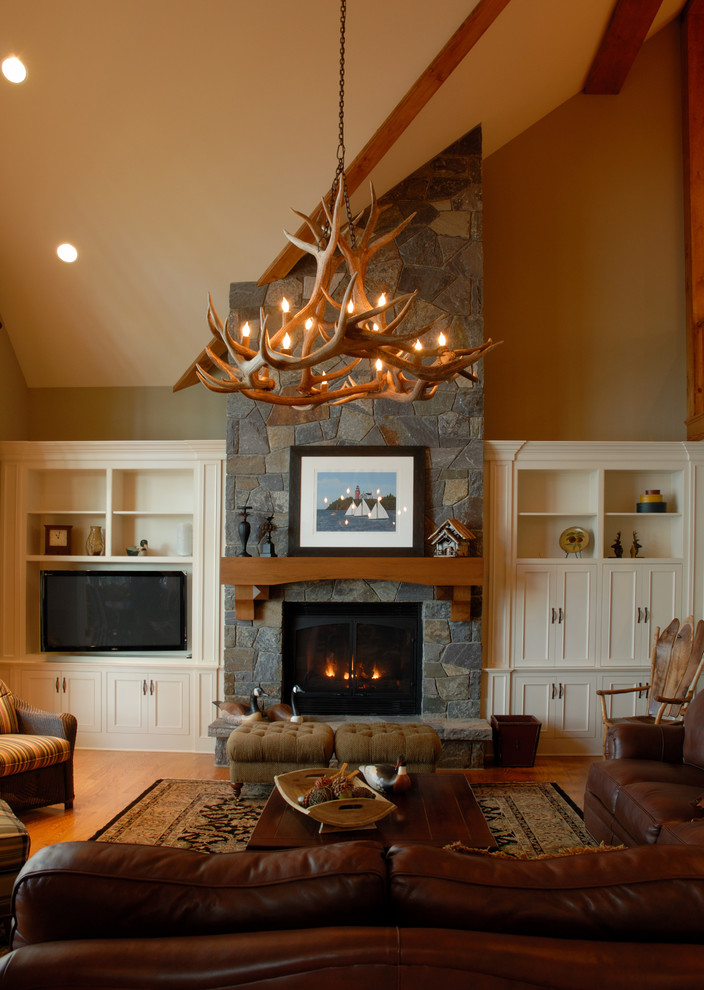 Cette photo montre un grand salon tendance ouvert avec une salle de réception, un mur beige, un sol en bois brun, une cheminée standard, un manteau de cheminée en pierre et un téléviseur indépendant.