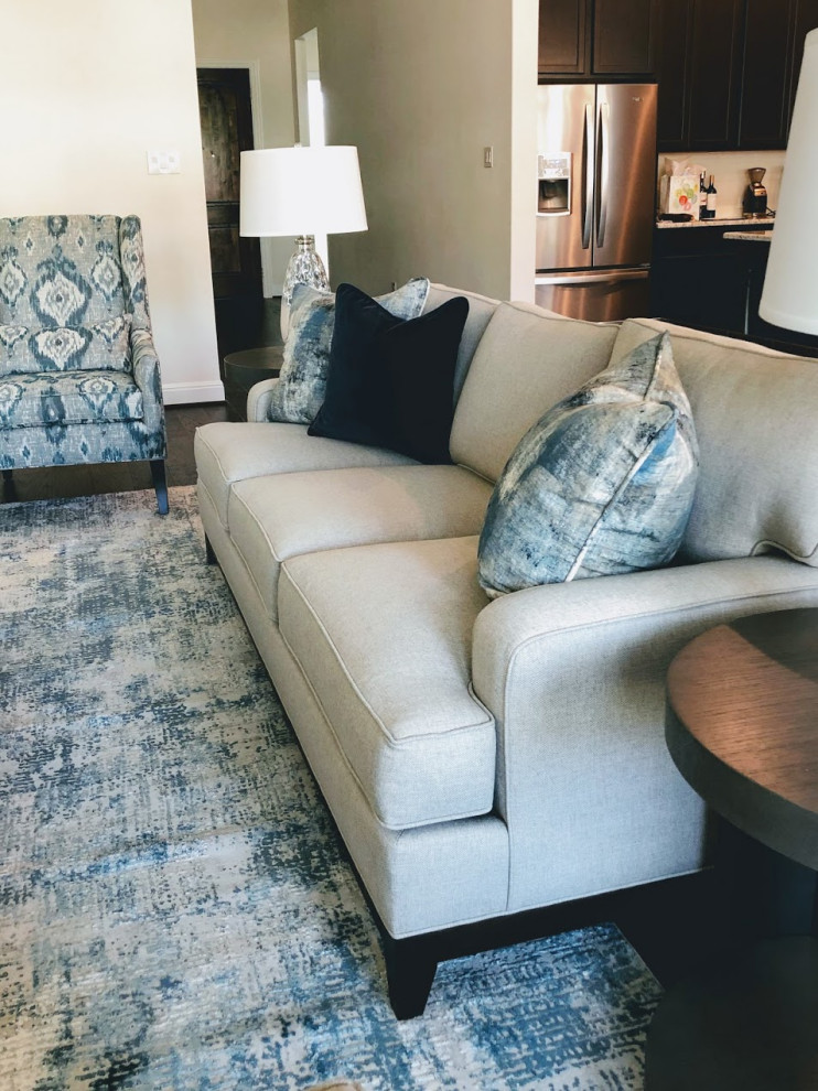 Mittelgroßes, Offenes Klassisches Wohnzimmer mit weißer Wandfarbe, braunem Holzboden, Eckkamin, verputzter Kaminumrandung, freistehendem TV und braunem Boden in Austin