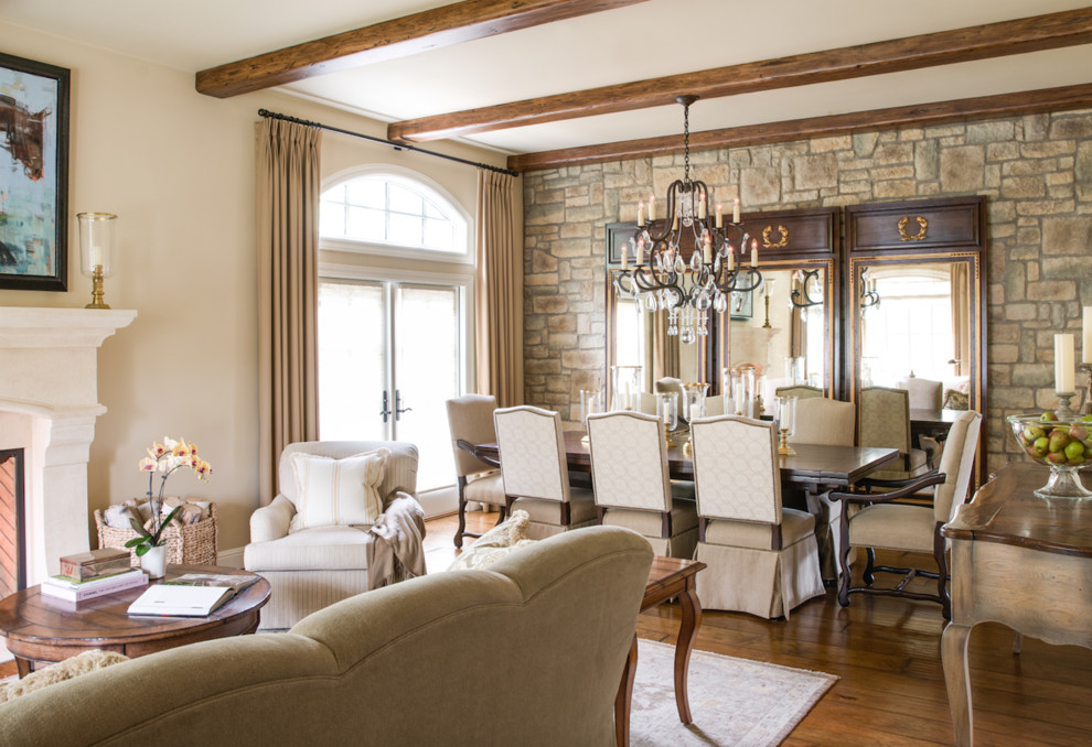 Klassisk inredning av ett stort separat vardagsrum, med ett finrum, beige väggar, mellanmörkt trägolv, en standard öppen spis, en spiselkrans i sten och brunt golv