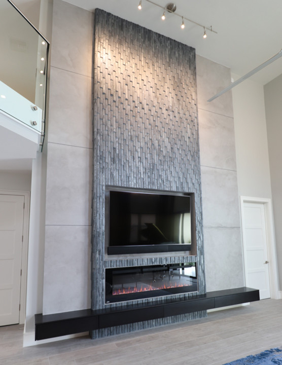 Imagen de salón minimalista con paredes beige, chimenea lineal, marco de chimenea de baldosas y/o azulejos y suelo gris