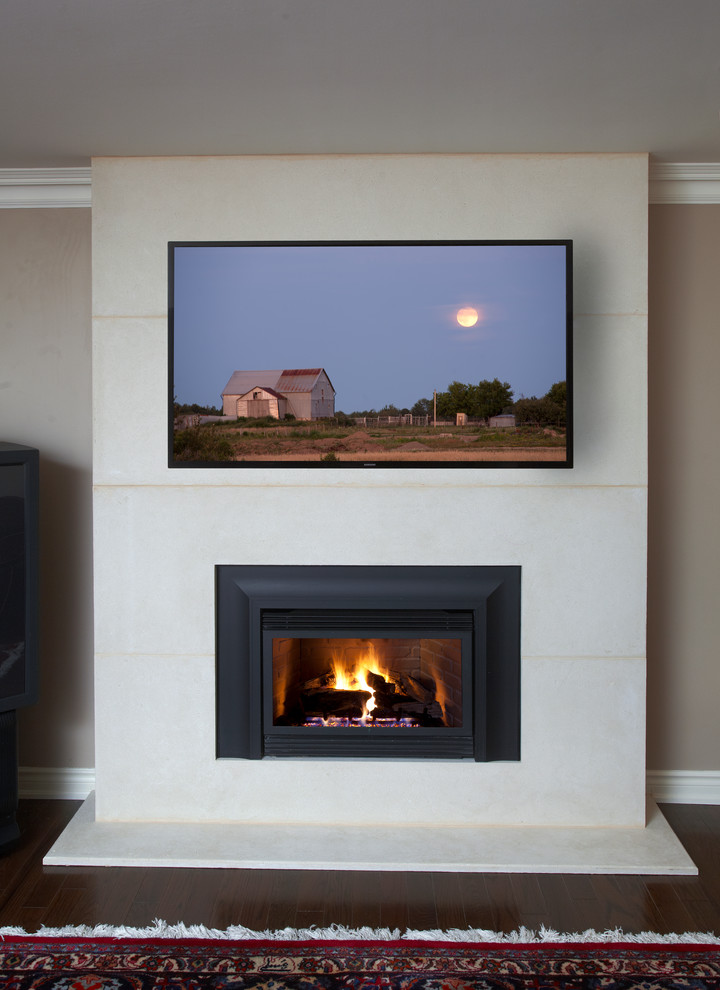 Diseño de salón para visitas cerrado contemporáneo pequeño con paredes beige, marco de chimenea de piedra, suelo marrón, suelo de madera en tonos medios, todas las chimeneas y televisor colgado en la pared