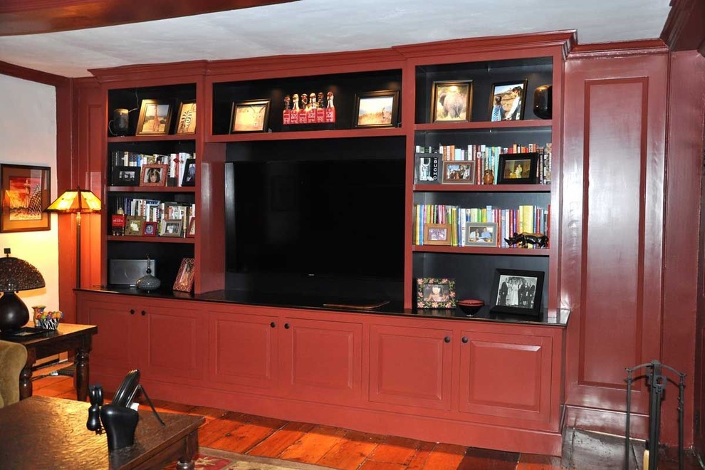Exemple d'un salon chic avec un mur blanc, un sol en bois brun et un téléviseur encastré.